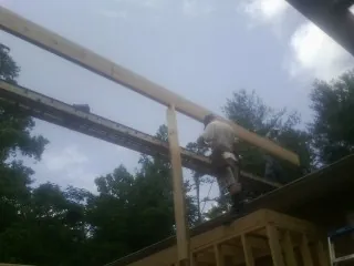 Carpenter setting a ridge beam over a new addition frame — Ice Dam Removal by Roofing Brothers in Cope