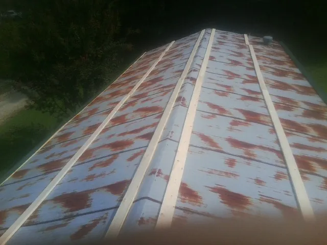Rusted metal roof panels with new wood purlins before replacement — Storm Damage Roof Repair in Cope by Roofing Brothers
